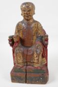 A Chinese carved wood figure of a dignitary seated on a throne, traces of paint, 9" high