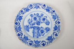 An early C19th Delft blue and white pottery charger painted with flowers, 14" diameter