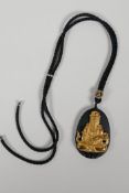 An oriental black glass pendant with carved and gilt Quan Yin decoration, A/F, chips, 1½" x 2"