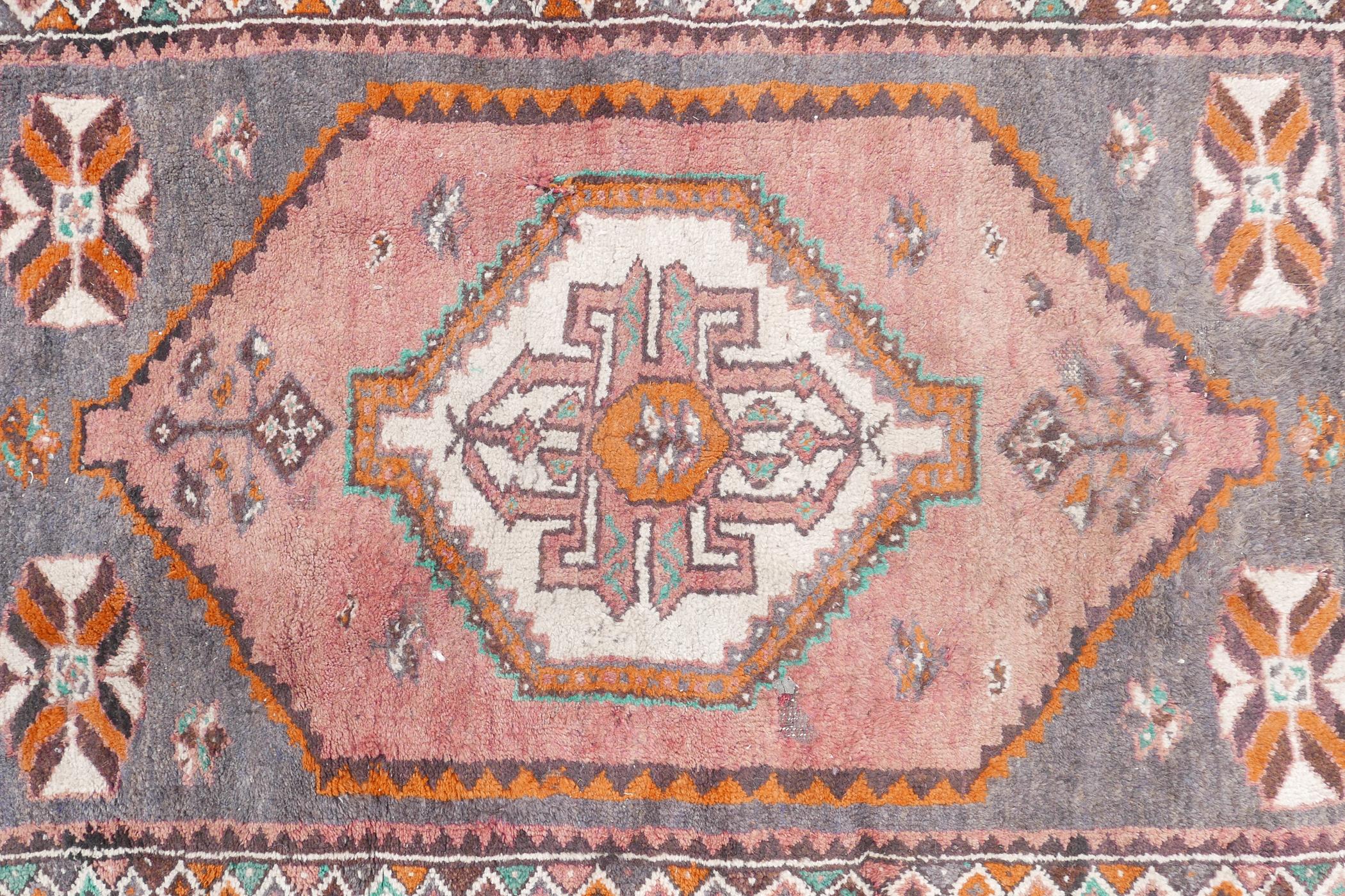 A full pile grey ground Afghan Belouch nomadic rug with pink medallion design and pink border, A/F - Image 2 of 5