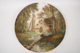 A pottery wall plaque painted with a woodland scene with building and figure, 15" diameter