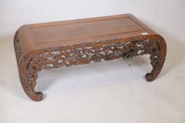 A Chinese hardwood low table with carved and pierced details depicting asiatic birds and prunus