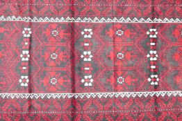 Hand woven full pile red and black ground Iranian Belouch rug, 50½" x 110"