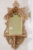 A C19th carved and pierced limewood tabernacle style wall mirror with shelf, 34" long