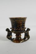 An English treacle glazed earthenware cup/goblet, with two handles in the form of leopards, marks to