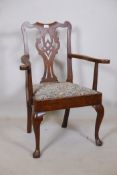 A Georgian Chippendale style walnut elbow chair, with pierced splat back scroll arms and drop in