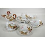 A Japanese eggshell porcelain Empress Head tea service, decorated with gilded dragon, teapot, four