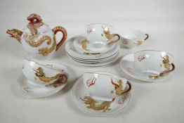 A Japanese eggshell porcelain Empress Head tea service, decorated with gilded dragon, teapot, four