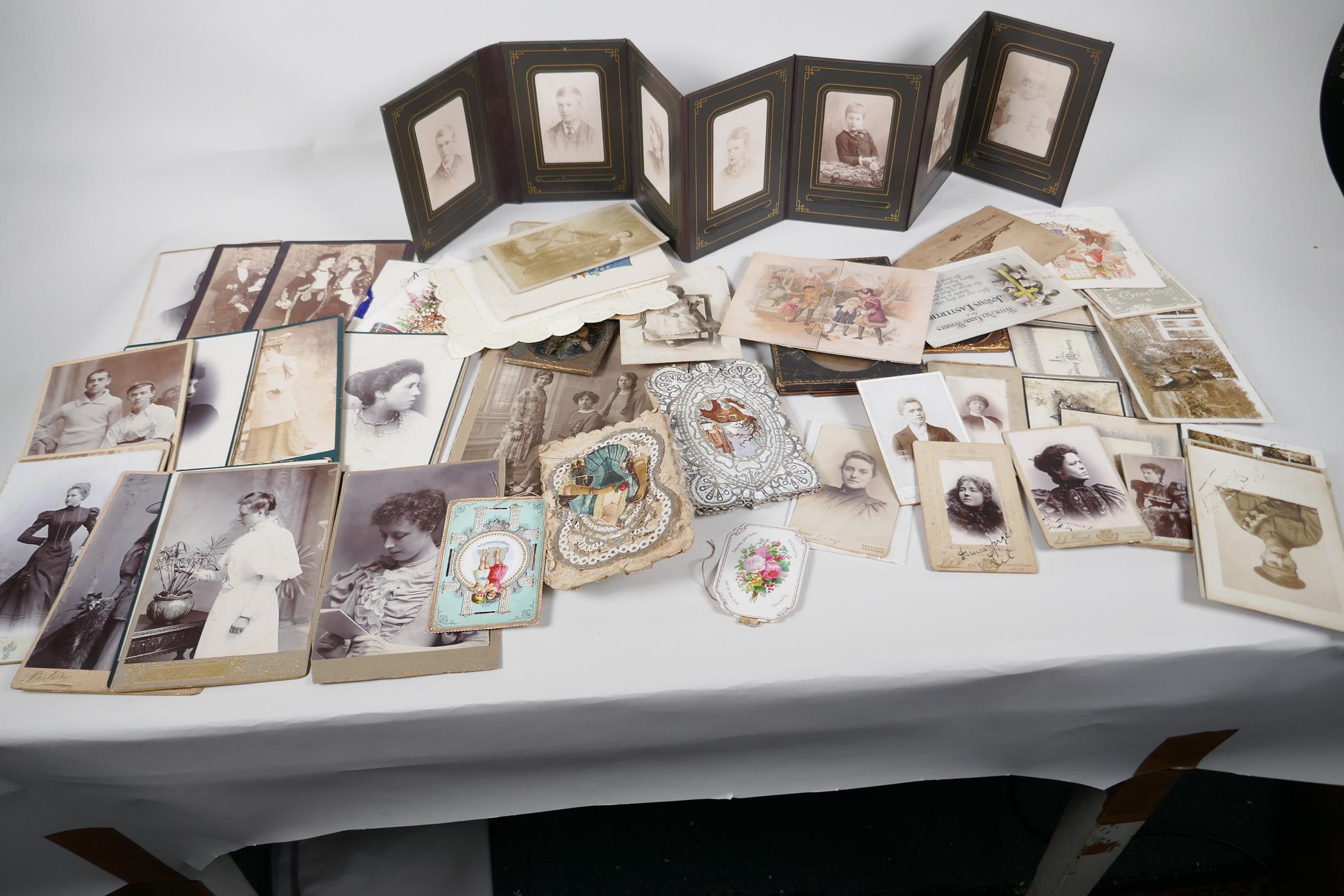 A quantity of C19th photographs and greeting cards, including a leather pocket family album