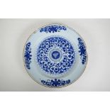An C18th/C19th Delft blue and white charger decorated with a hand painted floral pattern, A/F,
