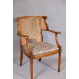 A 1930s bergere elbow chair, with shaped arms, back, cane back and seat