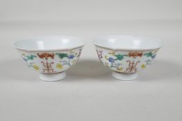 A pair of early C20th Chinese polychrome porcelain tea bowls, with lobed rims and enamel