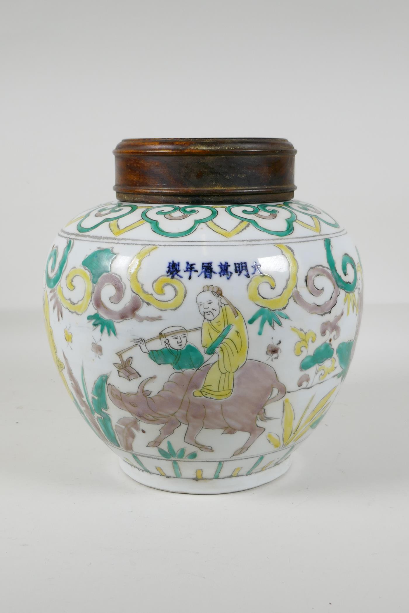 A Chinese Sancai glazed porcelain ginger jar with a turned wood cover, decorated with figures riding