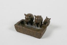 A Japenese Jizai style bronze of three pigs at a trough, impressed seal mark to base, 1½" wide