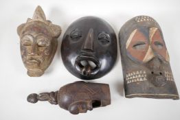 Three African carved wood tribal masks and a carved wood ceremonial bell, largest 13½" long