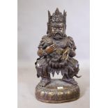 An antique Chinese bronze figure of an immortal, wearing a crown and clothed in armour hung with