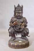 An antique Chinese bronze figure of an immortal, wearing a crown and clothed in armour hung with