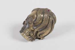A brass vesta case in the form of an octopus atop a skull