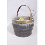 An antique coopered barrel log bin with brass handle and metal liner, 16" diameter x 11"