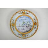 An C18th/C19th polychrome Delft charger decorated with a Dutch landscape, minor losses to glaze,