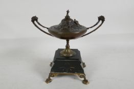 A C19th bronze urn and cover on a marble and ormolu stand, the cover cast with flowers and a bird,