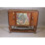 An Arts and Crafts oak side cabinet with painted central doors and undertier on cabriole supports,