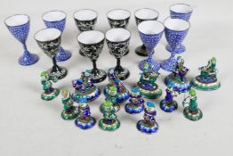 A quantity of oriental enamel figures, largest 2" high, and two sets of enamel goblets