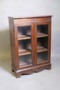 A mahogany cabinet, with two glazed doors, raised on bracket supports, 25" x 11" x 35"