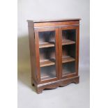 A mahogany cabinet, with two glazed doors, raised on bracket supports, 25" x 11" x 35"