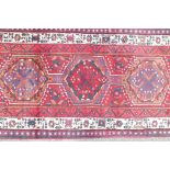 A full pile red ground hand woven Persian Heriz runner, small repair, 41" x 131"