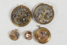 Three small Omega watch movements and two larger, one marked Brevet