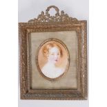 An early C19th miniature portrait of a Georgian child, in elaborate gilt metal frame, portrait 1½" x