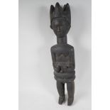 An African carved wood fertility figure holding a baby, 23" high