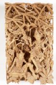 A Balinese carved sandlewood wall plaque, carved as two dancers resting under a tree, 16" x 9½"