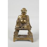 A Chinese gilt bronze of a Lohan seated on a throne, impressed character mark verso, 6" high