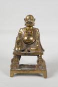 A Chinese gilt bronze of a Lohan seated on a throne, impressed character mark verso, 6" high