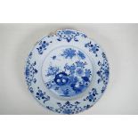 An C18th/C19th Delft blue and white charger with hand painted decoration of a garden landscape,
