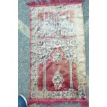 A red ground tassled prayer rug depicting two Mosques, 42" x 23"