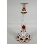A C19th Bohemian white over cranberry glass candlestick, with gilded decoration, 13" high