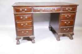 An Edwardian mahogany nine drawer pedestal desk, with swan neck handles and moulded front drawers,