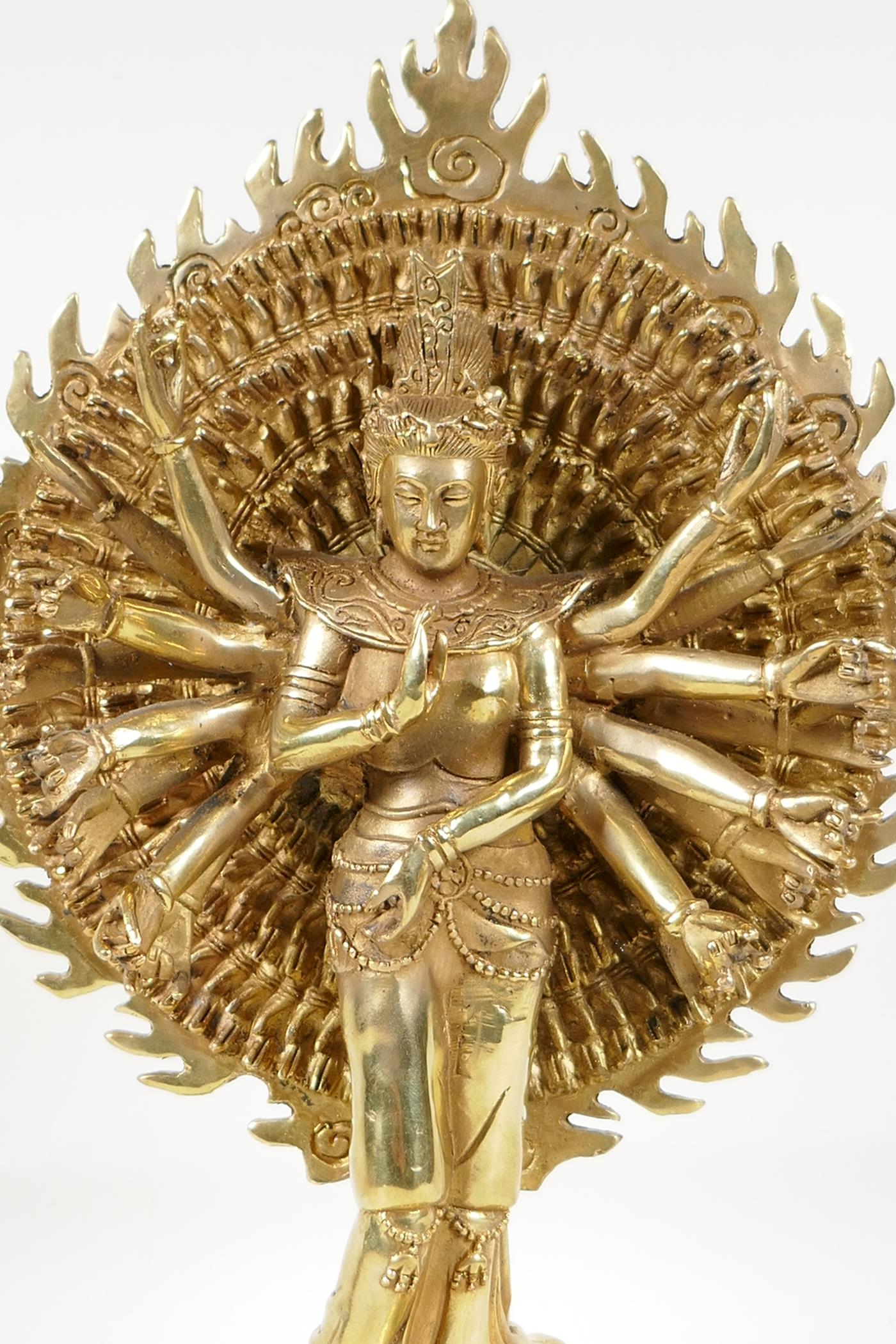 A Sino-Tibetan gilt bronze of a deity with many arms, on a lotus flower, 12½" high - Image 2 of 5