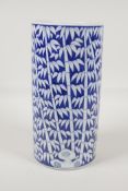 A Chinese black & white porcelain cylinder vase with bamboo forest decoration. 10" high x 5"