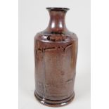 A drip glazed stoneware bottle vase of tubular design with narrow neck, 7½" long