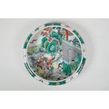 A famille vert porcelain dish with a rolled rim and  decorated with warriors on horseback, Chinese