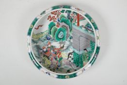 A famille vert porcelain dish with a rolled rim and  decorated with warriors on horseback, Chinese