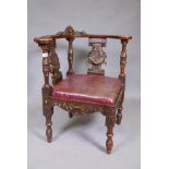 A C19th walnut corner chair with carved bow back, splats and shaped seat rails, the carving