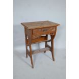 A satin walnut canterbury with carved Moorish Liberty style decoration and single drawer, A/F,