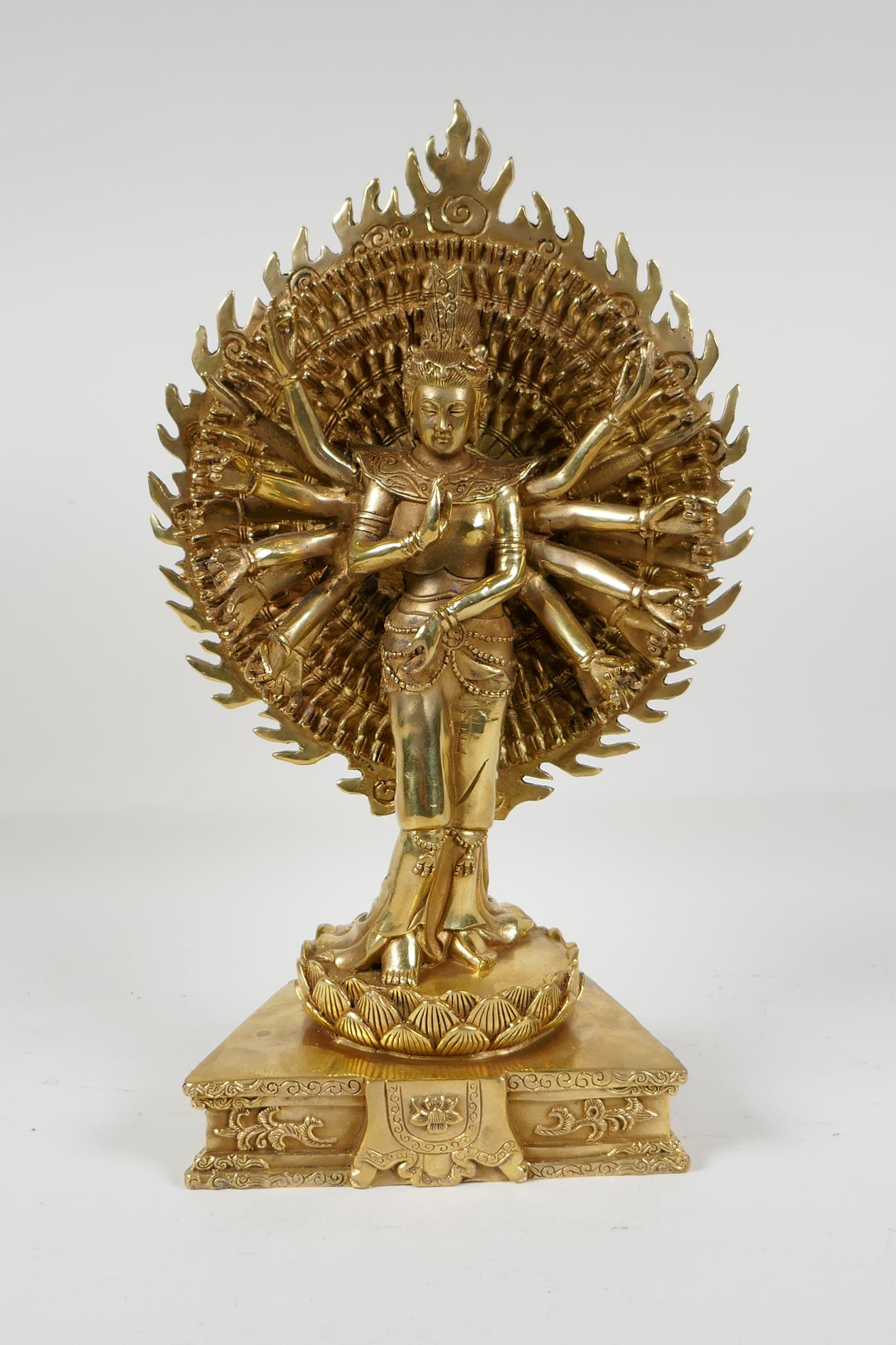 A Sino-Tibetan gilt bronze of a deity with many arms, on a lotus flower, 12½" high