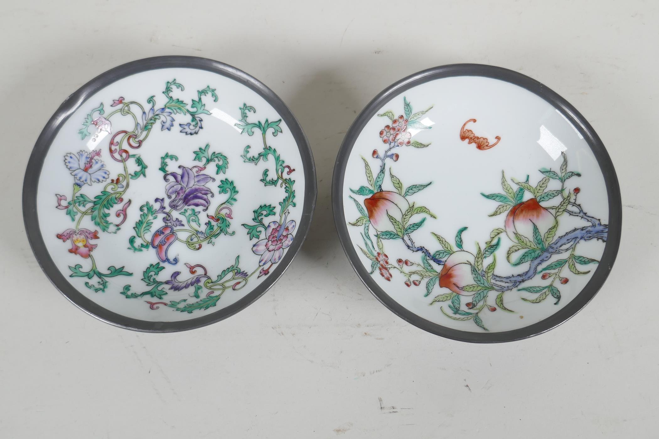 A pair of Chinese porcelain bowls painted with fruit flowers and bats, encassed in pewter frames. 6"