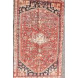 A Persian Heriz hand woven red and black ground wool rug with an all over design and cream border,